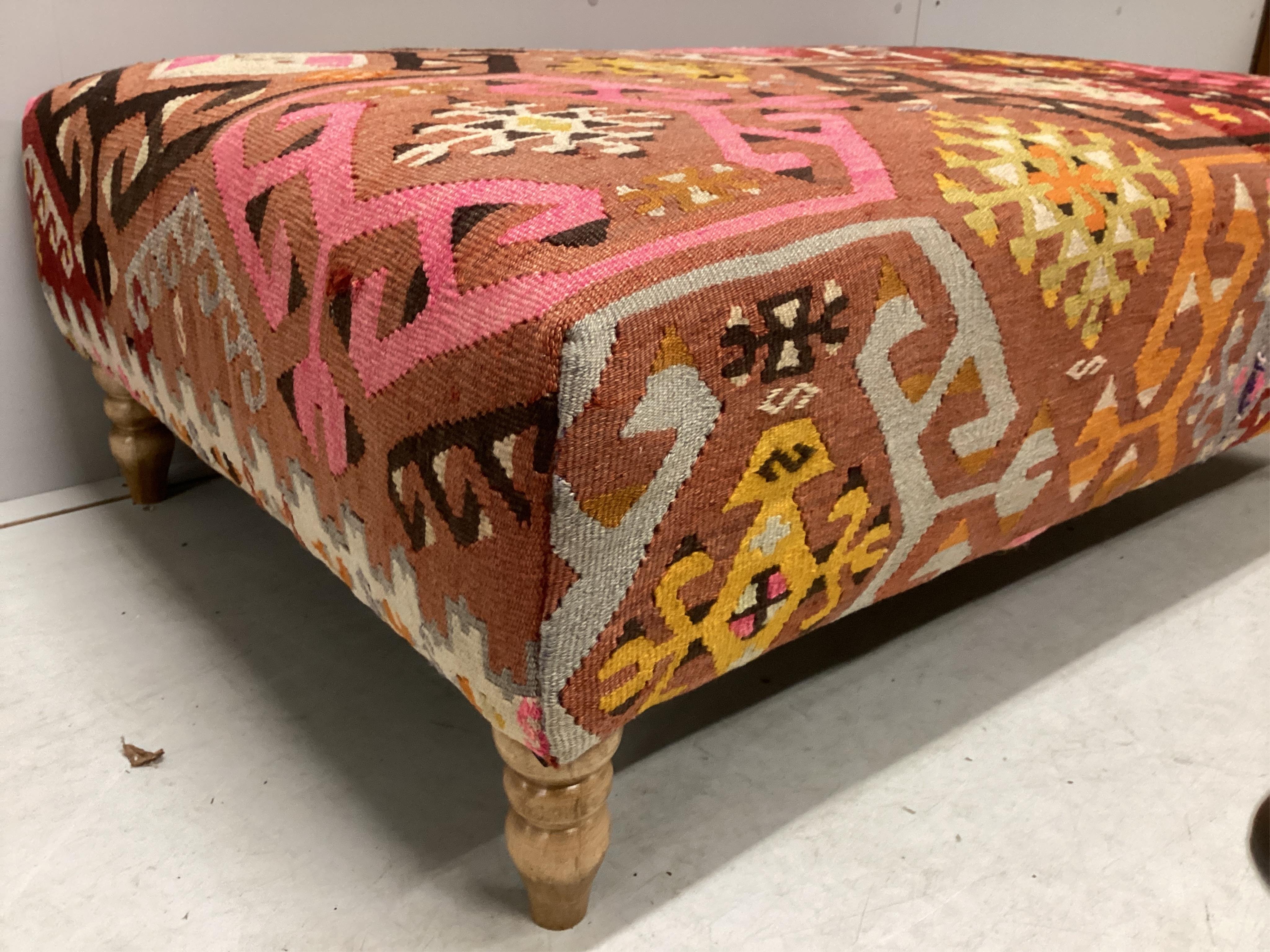 A large contemporary rectangular footstool with antique polychrome Kilim upholstery on turned beech feet, width 124cm, depth 78cm, height 40cm. Condition - good